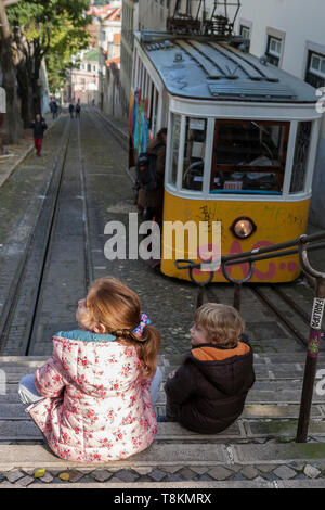 Due bambini attendere a bordo del ascensor da Glória tram alla sommità del Calçada da Glória nel Bairro Allto, Lisbona, Portogallo Foto Stock