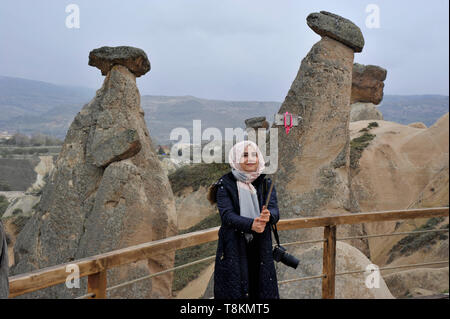 Una giovane donna musulmana prende un selfie a Cappadocia, Turchia Foto Stock