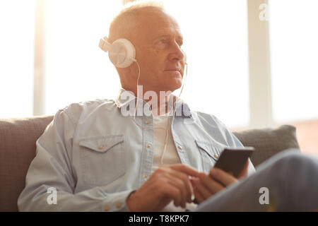 Senior uomo ascoltare musica Foto Stock