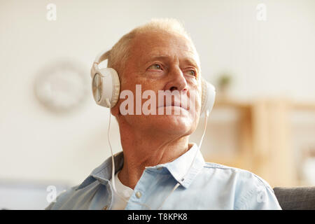Malinconici Senior uomo ascoltare musica Foto Stock