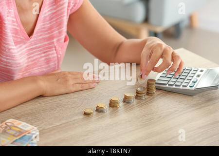 Donna matura conteggiare denaro a casa, primo piano Foto Stock