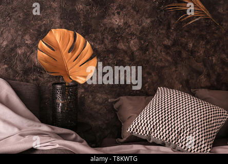 Vaso con Golden foglia tropicale nell interno del moderno e confortevole camera da letto Foto Stock