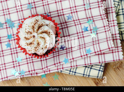 Red Velvet cupcake su plaid tessuto decorativo con stelle e una profondità di campo ridotta Foto Stock