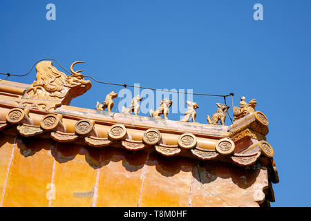 Il tetto del tempio tradizionale Cinese con orange di piastrelle di ceramica e un ornati in pietra rossa gable Foto Stock