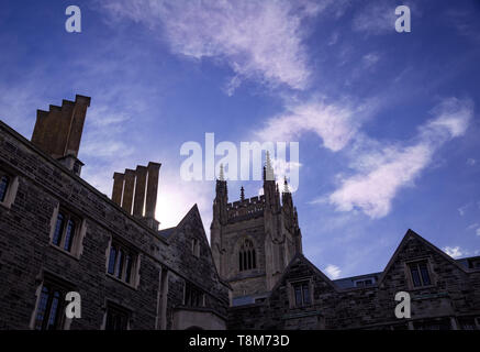 Vista al tramonto su una architettura gotica edificio di fronte di luminoso cielo blu con il bianco cirrus nuvole. Foto Stock