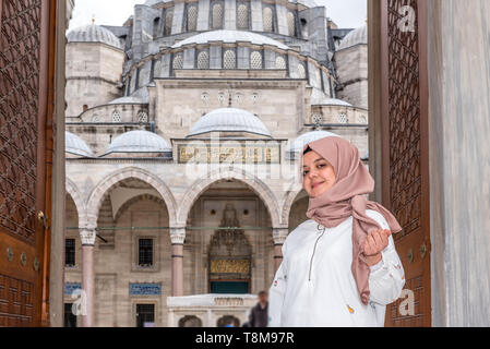 Bella donna musulmana in velo e alla moda moderno vestiti alla moda pone al cancello della Moschea Suleymaniye in Istanbul, Turchia.Moderna donne musulmane l Foto Stock