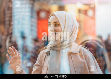 Bella donna musulmana in velo e moderno e alla moda abiti abiti appare sul display.Moderne le donne musulmane di stile di vita o travel tourist concept Foto Stock