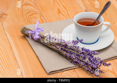 Il tè caldo in una tazza con la lavanda su un tovagliolo di lino close-up Foto Stock