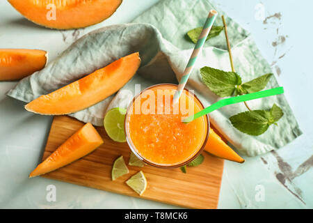 Bicchiere di gustoso frullato di melone sul tavolo Foto Stock