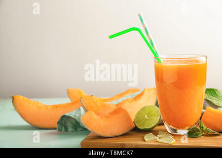 Bicchiere di gustoso frullato di melone sul tavolo Foto Stock