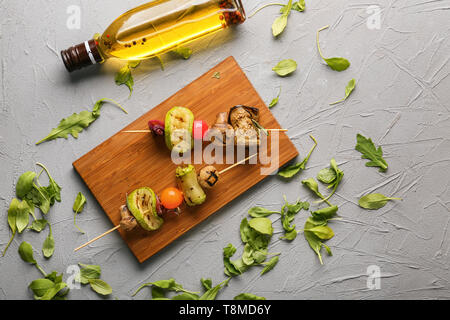 Spiedini con gustose verdure grigliate sulla tavola di legno Foto Stock