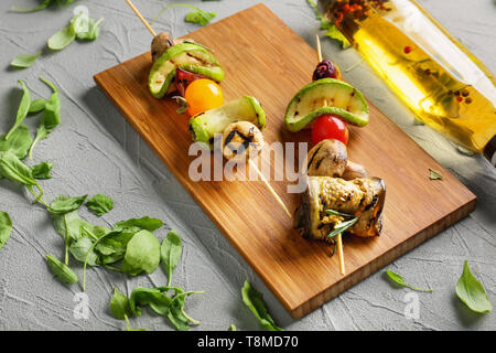 Spiedini con gustose verdure grigliate sulla tavola di legno Foto Stock