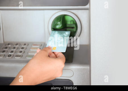 Donna l'inserimento di carta di credito nella macchina di cassa, primo piano Foto Stock