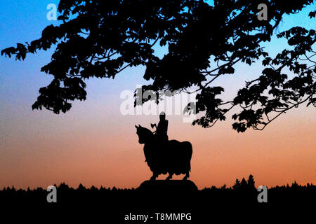 Il sole tramonta dietro la statua di Robert the Bruce sul suo cavallo di guerra nella Battaglia di Bannockburn sito nelle vicinanze di Stirling. Foto Stock