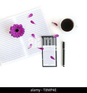 Lay piatto aprire la Bibbia o il libro e rosa, viola, viola, rosso Gerbera fiore su uno sfondo bianco. Con petali di rosa, tastiera, tè nero, lista Da fare Foto Stock
