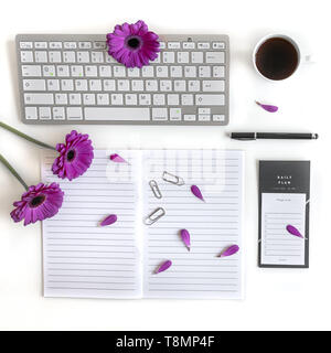 Lay piatto aprire la Bibbia o il libro e rosa, viola, viola, rosso Gerbera fiore su uno sfondo bianco. Con petali di rosa, tastiera, tè nero, lista Da fare Foto Stock