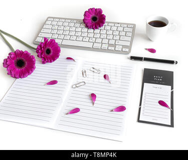Lay piatto aprire la Bibbia o il libro e rosa, viola, viola, rosso Gerbera fiore su uno sfondo bianco. Con petali di rosa, tastiera, tè nero, lista Da fare Foto Stock