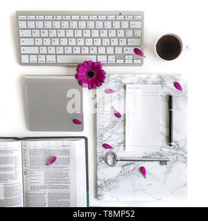 Lay piatto aprire la Bibbia o il libro e rosa, viola, viola, rosso Gerbera fiore su uno sfondo bianco. Con petali di rosa, tastiera, tè nero, lista Da fare Foto Stock