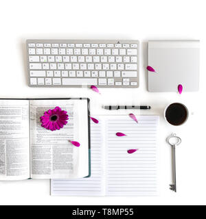 Lay piatto aprire la Bibbia o il libro e rosa, viola, viola, rosso Gerbera fiore su uno sfondo bianco. Con petali di rosa, tastiera, tè nero, lista Da fare Foto Stock