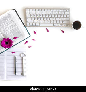 Lay piatto aprire la Bibbia o il libro e rosa, viola, viola, rosso Gerbera fiore su uno sfondo bianco. Con petali di rosa, tastiera, tè nero, lista Da fare Foto Stock