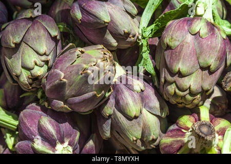 Fresco verde i carciofi in una pila al mercato Foto Stock