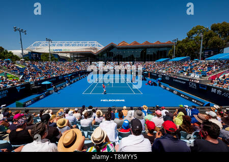 Ventilatori per partecipare ad una partita di tennis durante l'australiano Aperta sulla corte esterna 3 con la Rod Laver Arena e Margaret Court Arena in background. Foto Stock