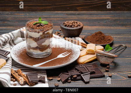 Tiramisù classico dessert in un bicchiere su sfondo di legno Foto Stock