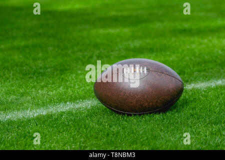 Football americano, rugby palla su erba verde dello sfondo dei campi Foto Stock