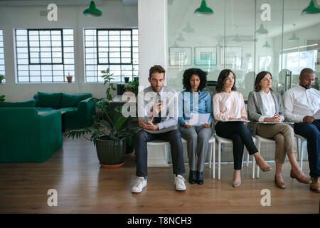 La gente seduta in un ufficio in attesa per colloqui di lavoro Foto Stock