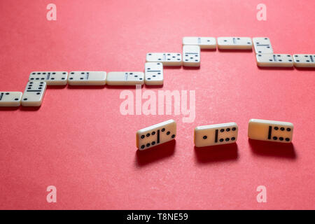 Il gioco di domino pezzi su un rosso superficie colorata Foto Stock