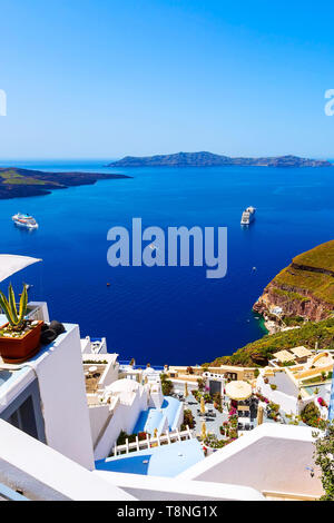 Santorini, Grecia iconico vista di case bianche, caldera, isola di Vulcano e panorama sul mare con la nave da crociera Foto Stock