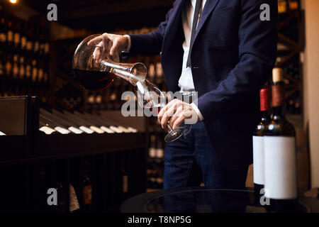 Giovane uomo la miscelazione di vini. creazione del vino indimenticabile. concetto d'arte. close up foto ritagliata Foto Stock