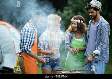 Gruppo di amici divertendosi in natura facendo il barbecue Foto Stock