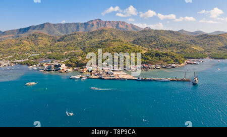 Una piccola città portuale della città di Coron, Filippine.Big Island con colline e città, vista da sopra.navi cargo e barche presso il molo.Filippine, Palawan Foto Stock