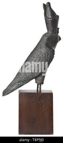 Un antica egiziana statuetta del falco Horus, tardo periodo, mid- per la seconda metà del I millennio A.C. il bronzo falcon con doppia corona. La circolare intarsio dorato dell'occhio destro è stato conservato. La superficie leggermente corroso, ivi visibili le linee dell'ex scalpellare per raffigurare il piumaggio. Il artigli e le parti inferiori delle gambe sono rotte. In una moderna base di legno. Altezza senza base 15 cm. Attraente, espressiva su piccola scala scultura. Provenienza: anni settanta collezione privata dalle zone di Monaco di Baviera. storica, storica, antica w, Additional-Rights-Clearance-Info-Not-Available Foto Stock