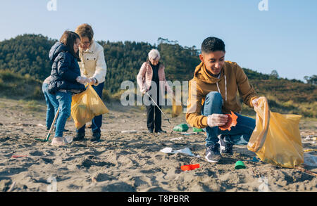 Giovane uomo pulizia della spiaggia Foto Stock