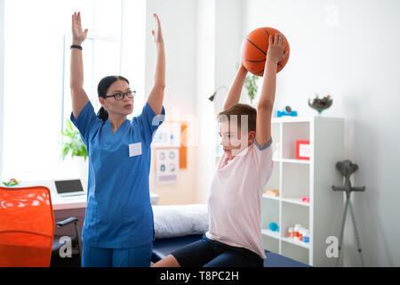 Serietà professionale fisioterapista alzando le mani Foto Stock