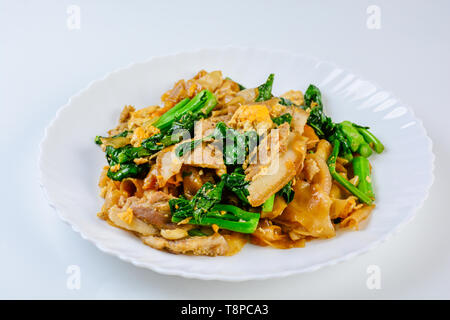 Saltati in padella il riso fresco-farina Tagliatelle con carne di maiale tagliata a fette, uovo e Kale. Quick noodle friggere. Foto Stock