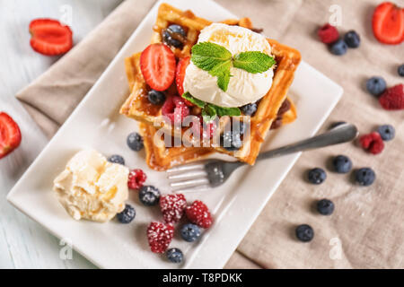 Deliziosi waffles con frutti di bosco e gelato su piastra Foto Stock