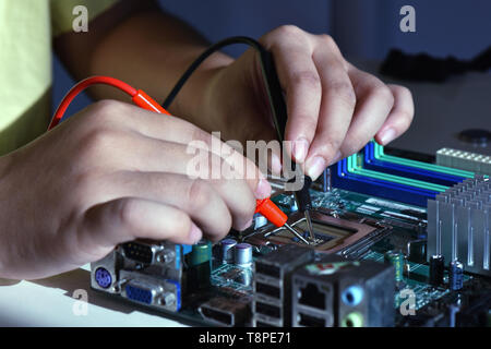 Chiudere fino a mani di ago punta a punta di lavoratore di servizio riparazione cpu computer. La riparazione e il concetto di servizio Foto Stock