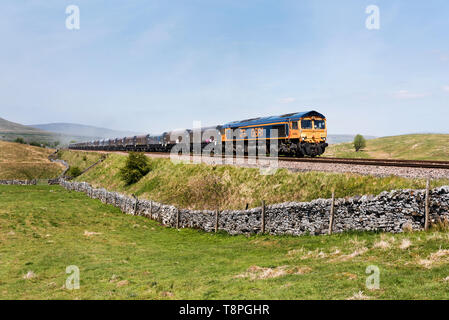 Un treno con un carico di pietra dalla cava Arcow, vicino a Horton in Ribblesdale, teste a sud oltre Selside sulla ferrovia Settle-Carlisle. Foto Stock