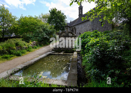 La piscina di acqua di fronte la piccola chiesa conservato borgo medievale di Locronan in Bretagna, Francia dipartimento di Finistère. Foto Stock