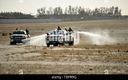 Ahmadi Governatorato, Kuwait. 14 Maggio, 2019. Lavoratori della pubblica autorità per l'agricoltura gli affari e le risorse ittiche (PAAAFR) spray insetticida durante la spruzzatura di pesticidi in campagna Wafra fattoria nel Governatorato Ahmadi, Kuwait, 14 maggio 2019. Sciami di locuste hanno causato pesanti perdite di materiale per molte aziende agricole in Kuwait. Credito: Asad/Xinhua/Alamy Live News Foto Stock