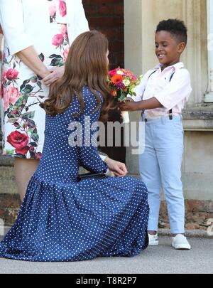 Kate Middleton, duchessa di Cambridge visto che gli viene data una posy di fiori da Lawson Bischoff come lei termina la sua visita il D-Day in mostra a Bletchley Park, Inghilterra. Foto Stock