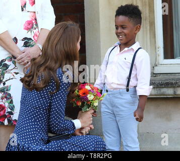 Kate Middleton, duchessa di Cambridge visto che gli viene data una posy di fiori da Lawson Bischoff come lei termina la sua visita il D-Day in mostra a Bletchley Park, Inghilterra. Foto Stock