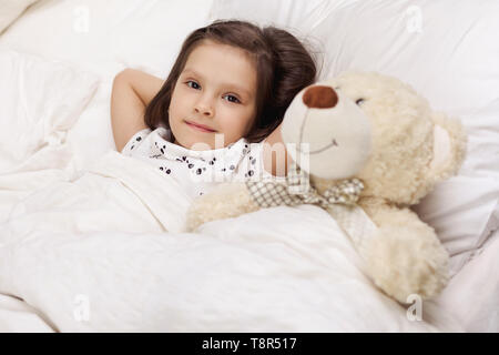 Grazioso fanciullo ragazza si riattiva dalla modalità di stop nel letto la mattina Foto Stock