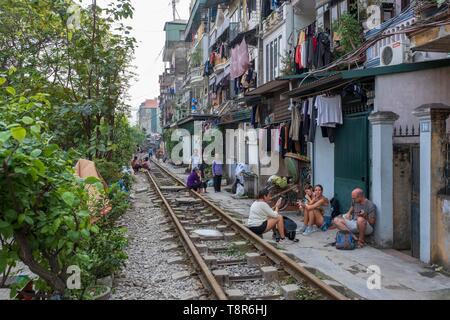 Il Vietnam, Hanoi, ferrovia che passa nel cuore della città vecchia, turisti in attesa per il passaggio di un treno Foto Stock