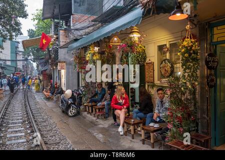 Il Vietnam, Hanoi, ferrovia che passa nel cuore della città vecchia, turisti in attesa per il passaggio di un treno Foto Stock