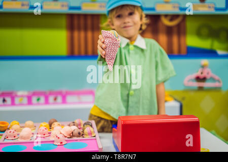 Un bambino gioca in un giocattolo cucina, rende un giocattolo di gelato Foto Stock