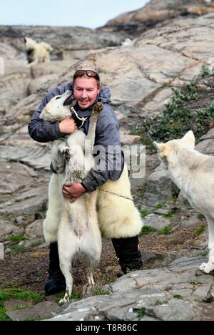 La Groenlandia, Costa Ovest, Uummannaq, lo Sled Dog allevatore Malti Suulutsun orso che indossa pantaloni di pelle Foto Stock